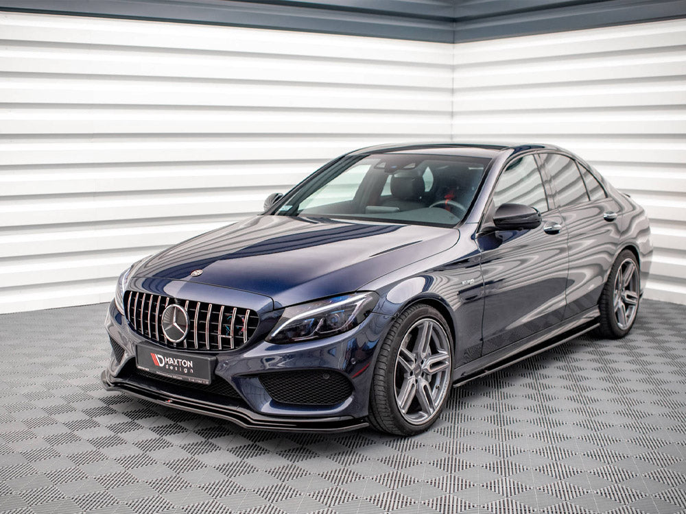 A dark blue sedan parked indoors on a checkered floor, featuring a prominent grille and alloy wheels. The license plate reads "HAXTON design." The wall is ridged with white panels.
