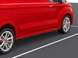 A red van is parked on a dark asphalt surface, with white parking lines visible. The focus is on the side, highlighting its sleek design and silver alloy wheels.