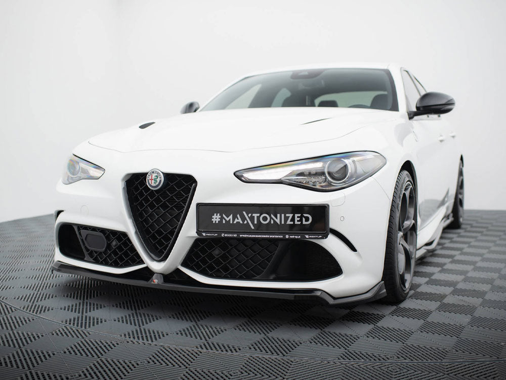 A white sports car is parked on a dark checkered floor in a studio setting. The car's front features a prominent grille, sleek headlights, and a license plate reading "#MAXTONIZED."