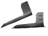 Two carbon fiber car accessories, possibly side skirts, lie against a plain white background. The pieces display a sleek, modern design with a diagonal striped pattern.