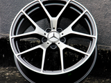 A metallic car wheel with a Mercedes-Benz logo and 