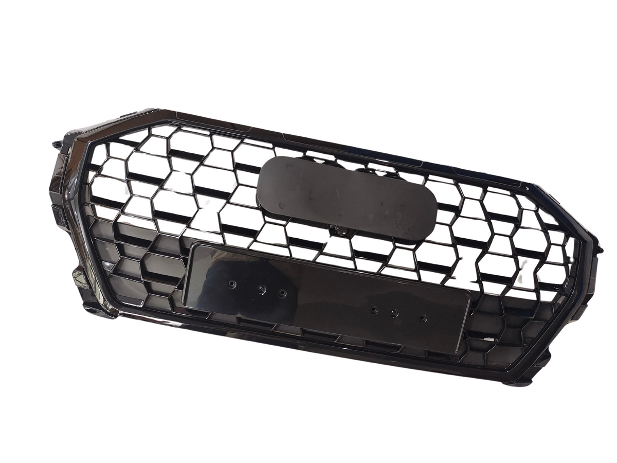 A black honeycomb car grille with an octagonal shape, featuring two rectangular mounting plates, lies against a plain white background.