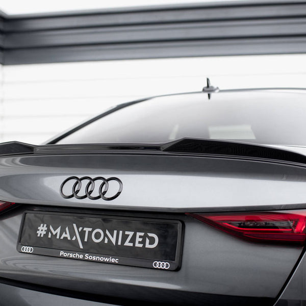 A gray Audi S3 car is parked in a garage. The rear features a spoiler, highlighted by red taillights, with a license plate reading "#MAXTONIZED Porsche Sosnowiec."