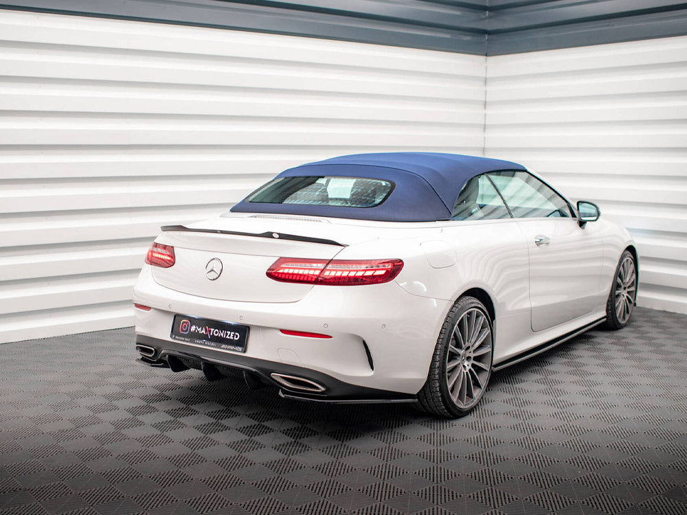 A white convertible car with a blue roof is parked in a modern, checker-patterned showroom. The license plate reads “@MA_TONIZED.”