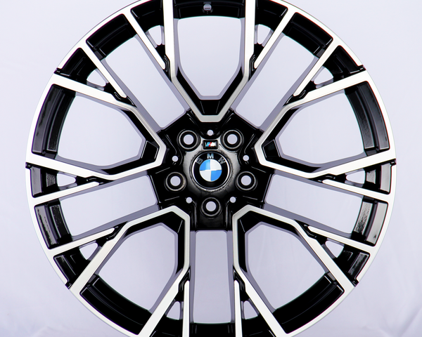The object is a car wheel rim with a sleek, multi-spoke, black-and-silver design, displaying a BMW emblem in the center. The context is a plain, white background.