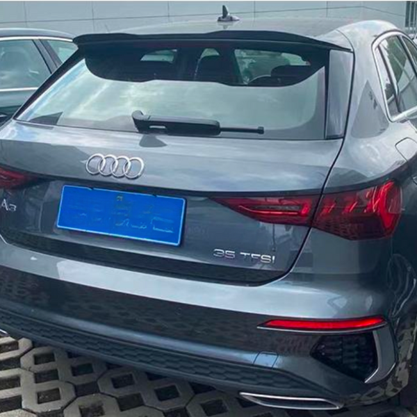 A gray Audi A3 car is parked on a patterned surface, adjacent to another vehicle. Text on the car reads "A3" and "35 TFSI." The weather is overcast.