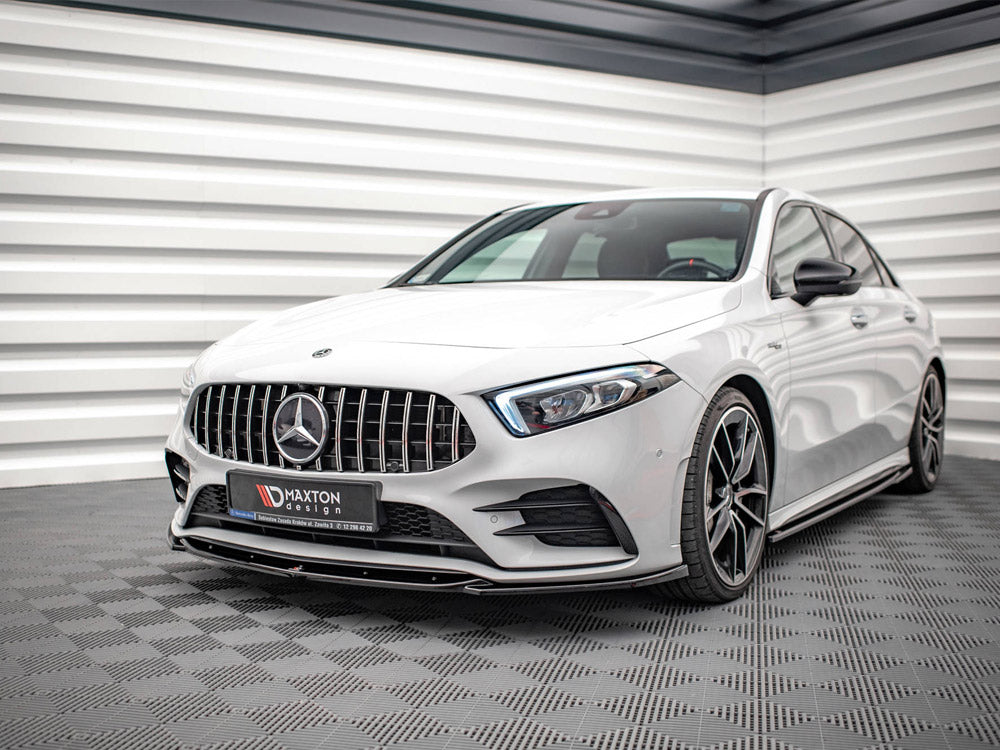 A white Mercedes car is parked on a checkered floor in a modern, sleek room with white paneled walls. The license plate reads "MAXTON design."