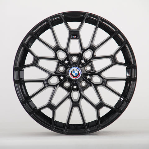 A black alloy wheel with intricate spokes is displayed, featuring a central BMW emblem. The wheel stands vertically against a plain white background.