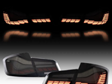 Car taillights illuminate with an orange glow, reflecting on a dark surface. Two individual taillight units are displayed below, showing their design and detailing against a gradient background.