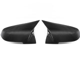 Two carbon fiber side mirror covers face each other on a white background, displaying a sleek, aerodynamic design with subtle texture and reflective finish. No text present.