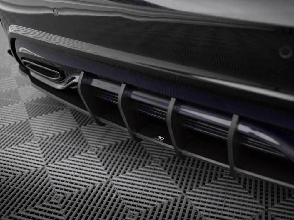 A sleek car diffuser with vertical slats at the rear, positioned above a textured, grid-patterned floor.