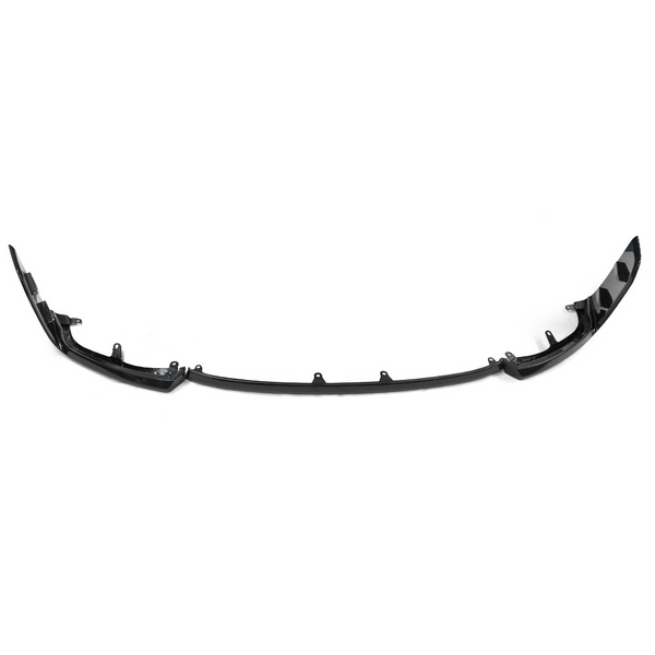 A black car bumper lip spoiler is laid on a plain white background. The structure curves upward at both ends, with several mounting points along its length.