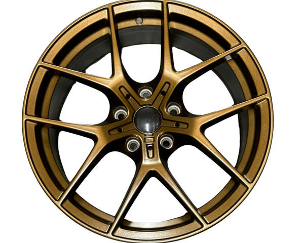 A bronze-colored alloy wheel with a five double-spoke design is positioned against a plain white background, showcasing intricate detailing and a central hub.