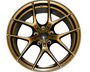 A bronze-colored alloy wheel with a five double-spoke design is positioned against a plain white background, showcasing intricate detailing and a central hub.