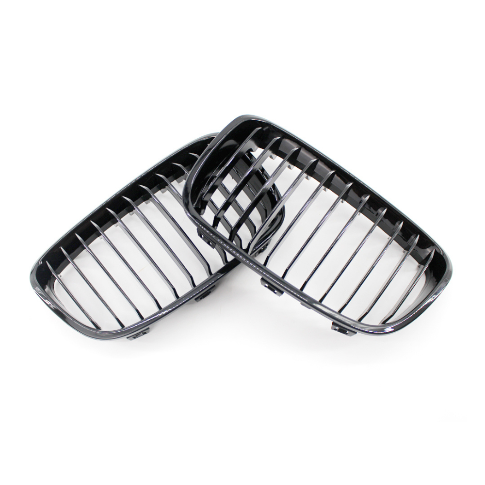 Two black vehicle grille covers, resting against each other, feature vertical slats, set against a plain white background.