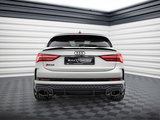 A white Audi RS Q3 sports car is stationary, viewed from the rear in a sleek, modern showroom with black and white walls. Text: 