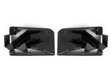 Two black carbon fiber air vents are positioned side by side, facing inward. They feature geometric, angular designs with a sleek, glossy finish, set against a plain white background.