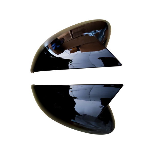 Two glossy, black, triangular structures are positioned with space between them, reflecting a room with boxes and overhead lights, set against a plain white background.