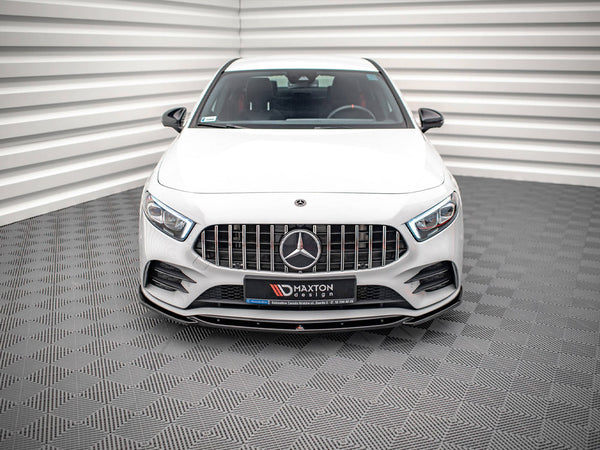 A white car is parked inside a patterned room. It features a prominent front grille with a logo and has text: “MAXTON DESIGN.” The background has textured walls and floor.