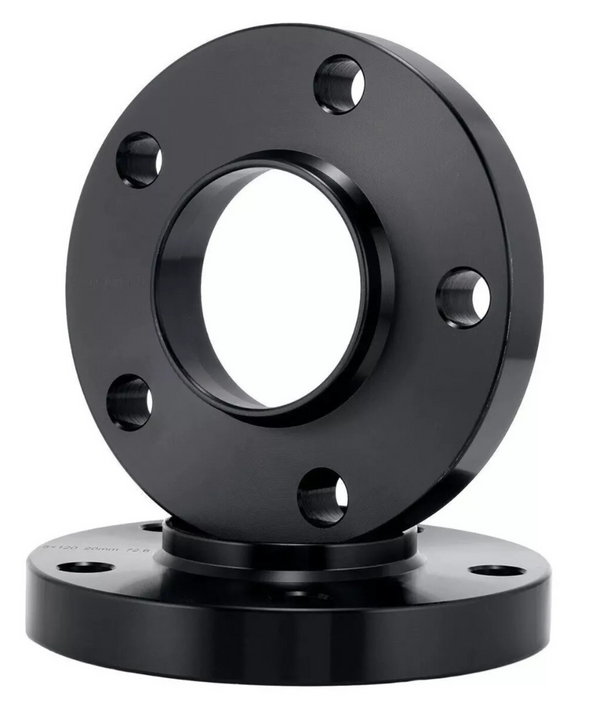 A black circular metal flange with a central hole and multiple bolt holes is displayed in front of a similar flange, set against a plain white background.