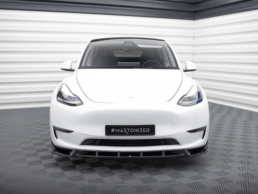 A white car is parked in a futuristic showroom with striped walls and a checkered floor. The license plate displays "#MAXTONIZED."