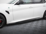 A white car is parked, showcasing its side view with a clover emblem near the front fender. It rests on a textured, patterned flooring.