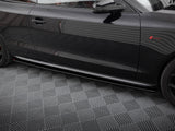 A shiny black car door with reflections parked on a patterned grey floor. The car features a red emblem and sleek design lines.