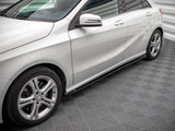 A silver car is parked on a patterned floor, displaying sleek design lines and alloy wheels. The setting has bright lighting and a textured surface, enhancing the vehicle's shine.