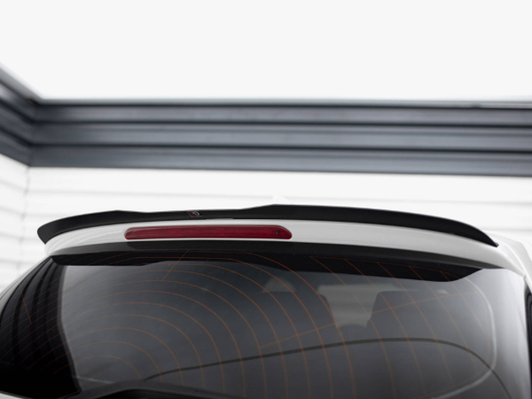 The rear window of a white car with a spoiler and a central brake light is shown; the car is parked in a garage with horizontal white and gray panels.