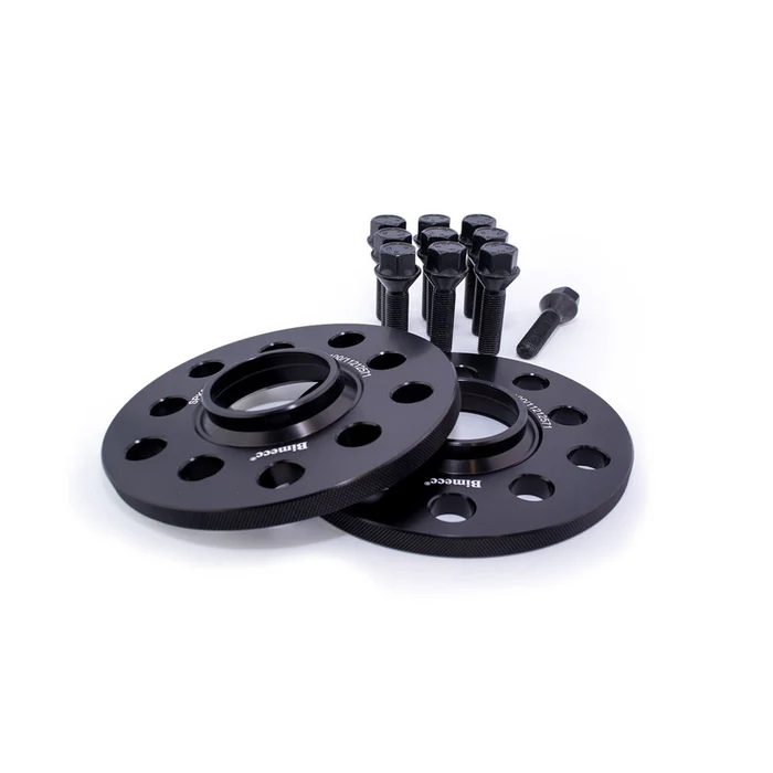 Black wheel spacers with holes, branded "Bimecc," lie on a white surface alongside ten black bolts, suggesting automotive equipment in a studio setting.