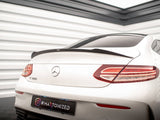 A white Mercedes-Benz C 300 is parked indoors, showcasing its rear with sleek taillights and a spoiler. The environment includes white paneled walls. The license plate reads 