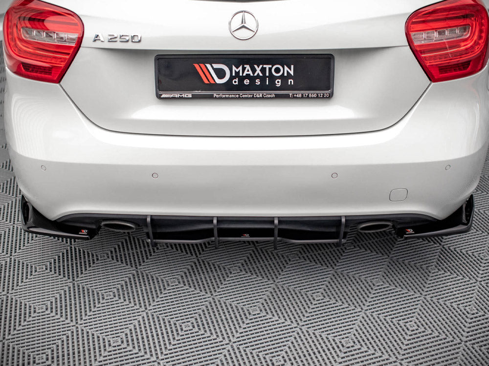 A white Mercedes A250 car is parked in a showroom on a checkered floor. The rear features a Maxton Design diffuser. The license plate reads "MAXTON design Performance Center D&R Czech T: +48 17 860 12 20."