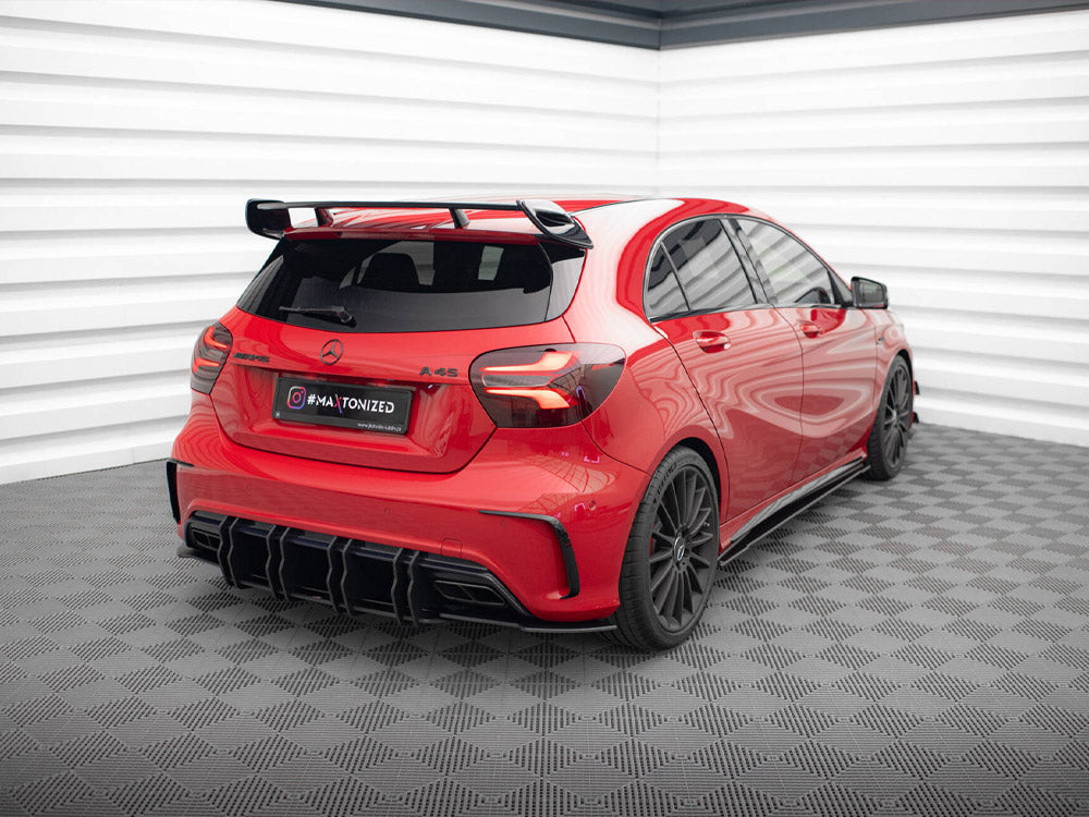 Red car with black accents sits stationary in a checkered-floor garage. Text on the plate reads "#MATONIZED." The walls are white with a layered design.