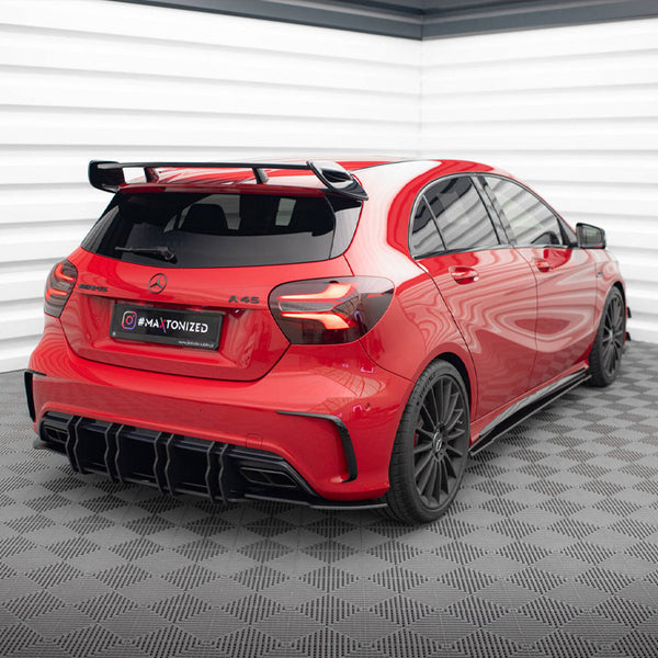 Red car with black accents sits stationary in a checkered-floor garage. Text on the plate reads "#MATONIZED." The walls are white with a layered design.