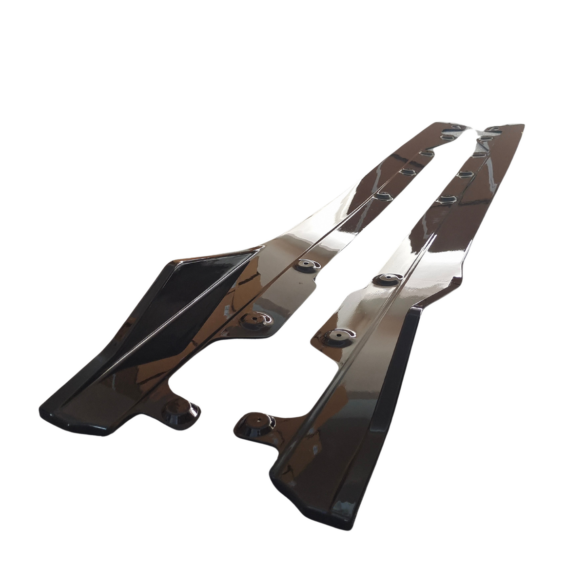 Two sleek, glossy black panels with multiple mounting holes lie side by side against a plain white background, reflecting light from above.