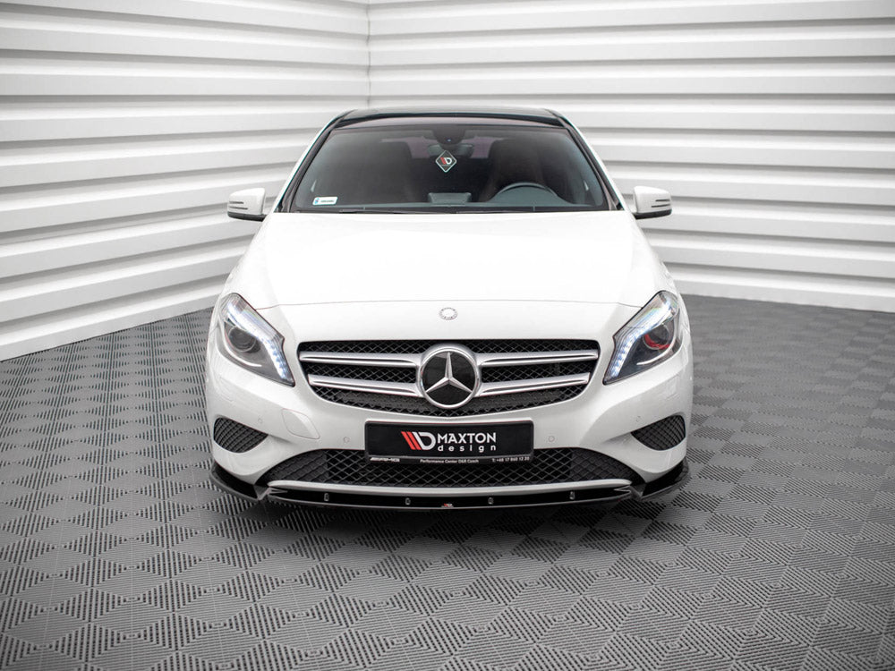 A white Mercedes-Benz car is parked in a room with patterned floors and striped walls. A front license plate reads "MAXTON design."