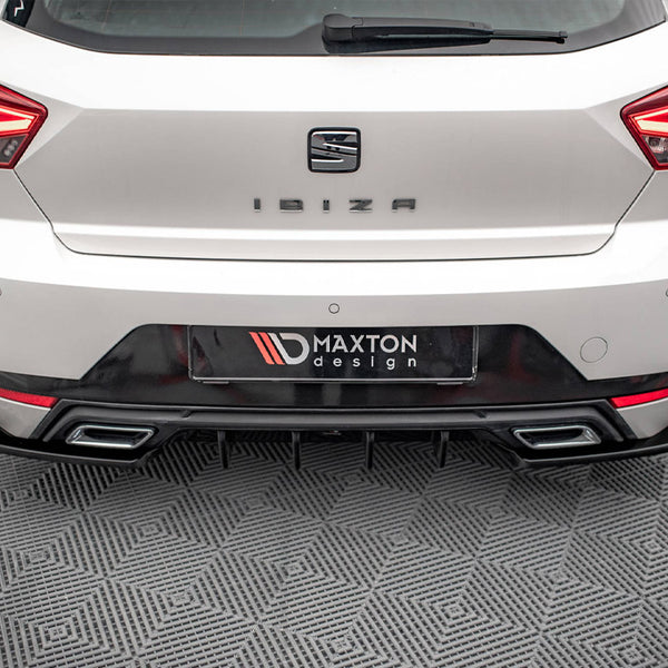 A white car's rear, labeled "IBIZA," is stationary on a patterned floor. The license plate reads "MAXTON design," surrounded by distinctive taillights and a dual exhaust.
