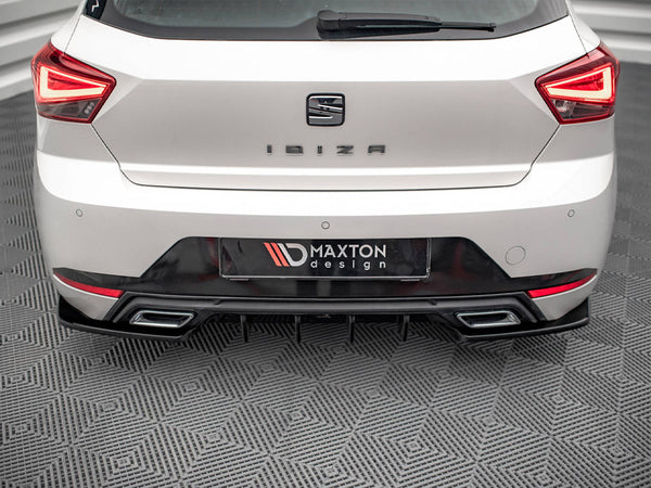 A white car's rear, labeled "IBIZA," is stationary on a patterned floor. The license plate reads "MAXTON design," surrounded by distinctive taillights and a dual exhaust.