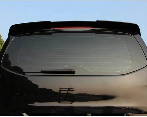 A black car with a rear window features a wiper and a spoiler on top. It is parked outdoors against a backdrop of trees and a clear blue sky.