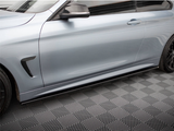 A silver car is parked on a patterned floor. The car's side features black trim and sleek, aerodynamic contours, with visible wheels and a closed door, reflecting a streamlined design.