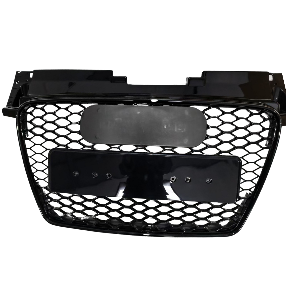Black car grille with honeycomb-pattern mesh, mounted on a smooth rectangular frame, featuring two blank plates. The grille is isolated, displayed against a plain white background.