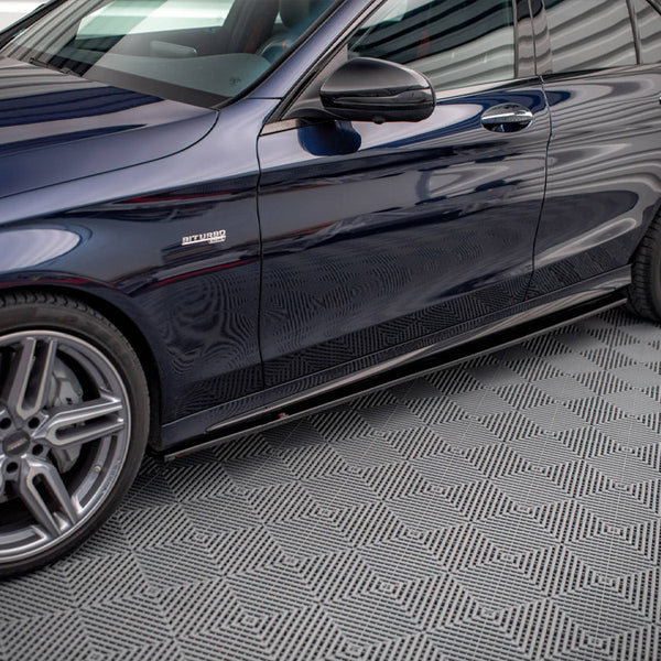 Car side view, parked in a garage with patterned flooring. The shiny, dark-colored vehicle displays "BITURBO" on the front side panel, highlighting a performance feature.