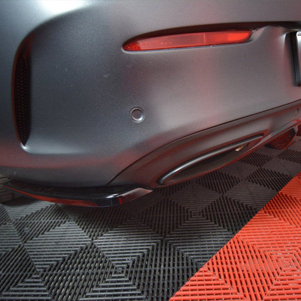 Car rear bumper with diffuser, parked on a checkered black and red mat. A license plate reads "MAXTON" with smaller text below, "maxtondesign.eu."