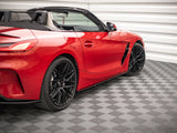 Red convertible sports car, parked, showcasing black wheels and sleek design. It sits on a patterned floor in a white-paneled garage.