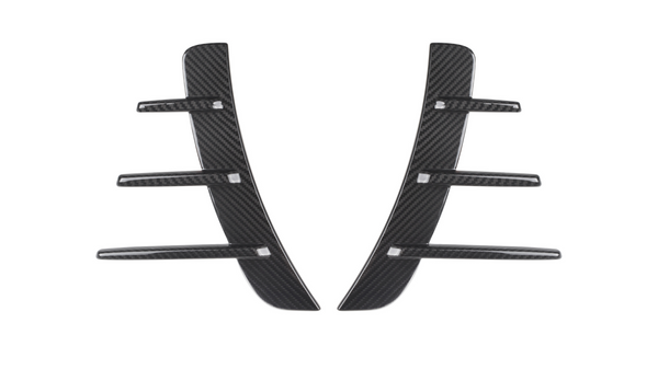 Carbon fiber car vent accents, featuring a central vertical piece with five horizontal fins, rest against a white background, showcasing their sleek and modern design.