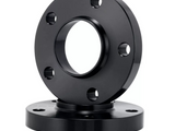 A black metal flange with circular openings, featuring evenly spaced bolt holes, stacks atop a similar component against a plain white background, indicating industrial use.
