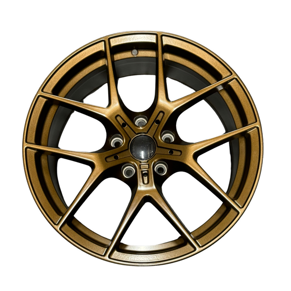 A metallic bronze alloy wheel with a multi-spoke design, displayed front-facing on a plain white background, showcasing its intricate style and smooth finish.