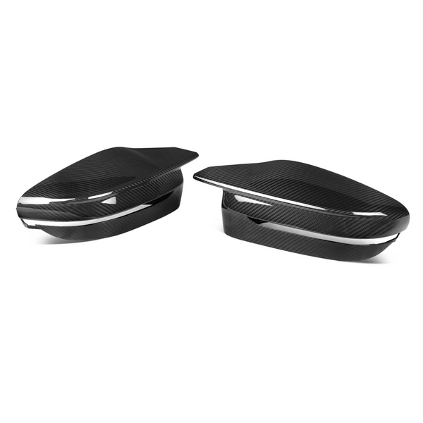 Two carbon fiber side mirror covers, sleek and glossy, rest on a plain white background. These aerodynamic accessories feature subtle lines and a streamlined design, emphasizing modern automotive style.