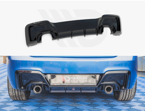 A black car diffuser, displayed separately above, is installed on the rear of a blue car, enhancing aerodynamics. The car sits on a blue patterned floor. Visible text: "MAXTON design".