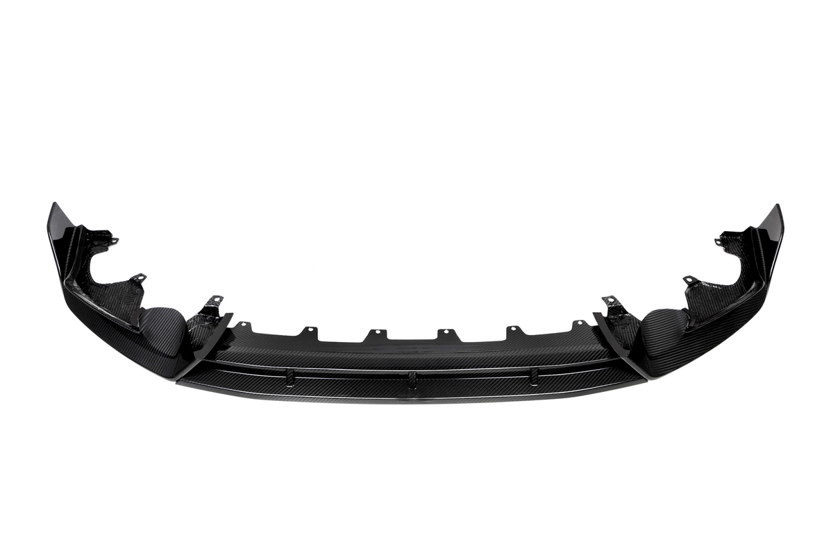 Curved black carbon fiber car bumper with mounting brackets, positioned horizontally against a plain white background, displaying a sleek design and intricate texture.